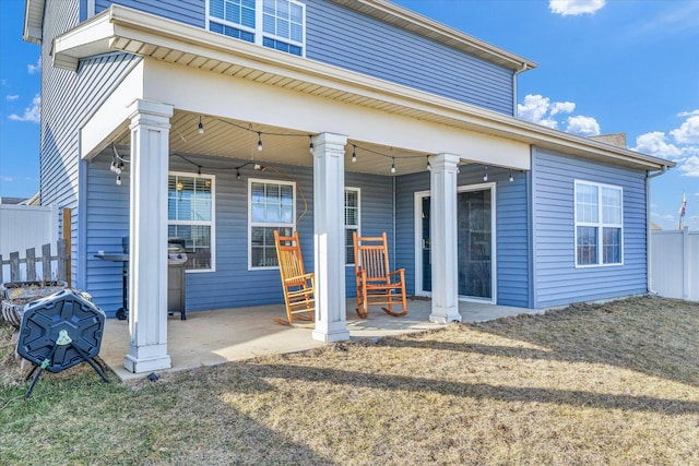 rear view of property with a patio area, fence, and a yard