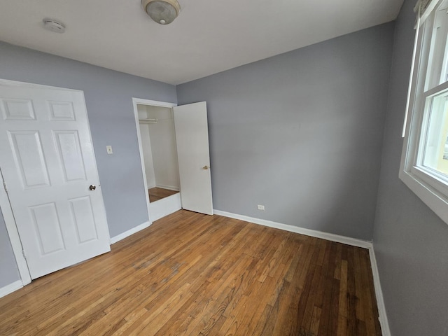 unfurnished bedroom with hardwood / wood-style floors and a closet