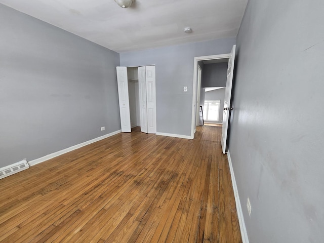 unfurnished bedroom with hardwood / wood-style floors and a closet