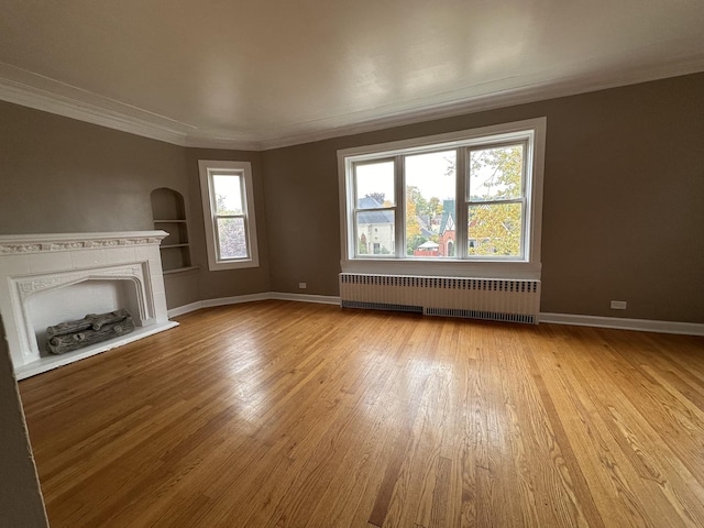 unfurnished living room with radiator, crown molding, and light hardwood / wood-style floors