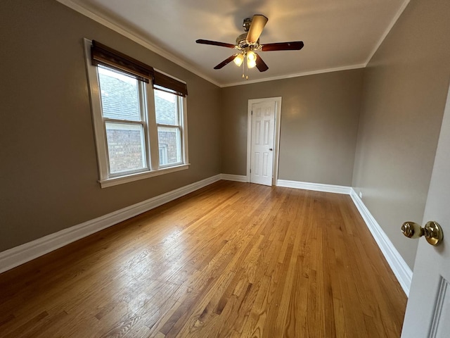 empty room featuring ornamental molding, ceiling fan, and light wood-type flooring