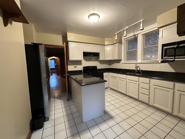 kitchen featuring black gas range oven, sink, white cabinetry, and stainless steel fridge