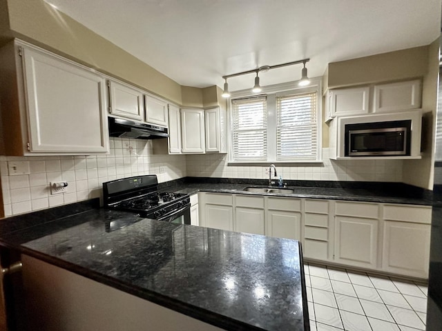 kitchen with black gas range oven, sink, dark stone countertops, and white cabinets