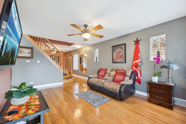 living room with light hardwood / wood-style flooring and ceiling fan