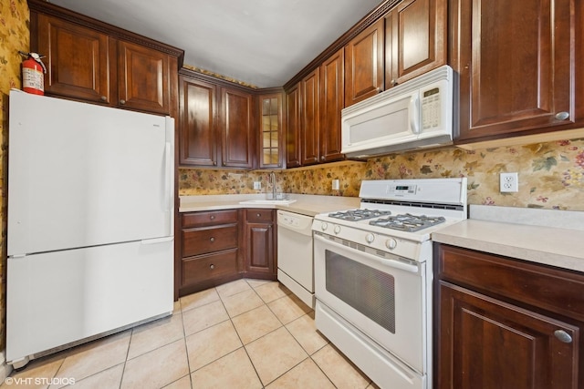 kitchen featuring sink, white appliances, light tile patterned floors, and decorative backsplash