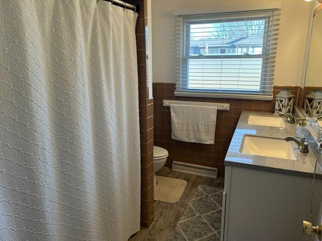 bathroom with vanity, tile walls, and toilet