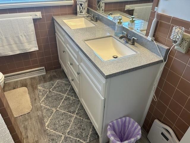 bathroom with vanity, wood-type flooring, toilet, and tile walls