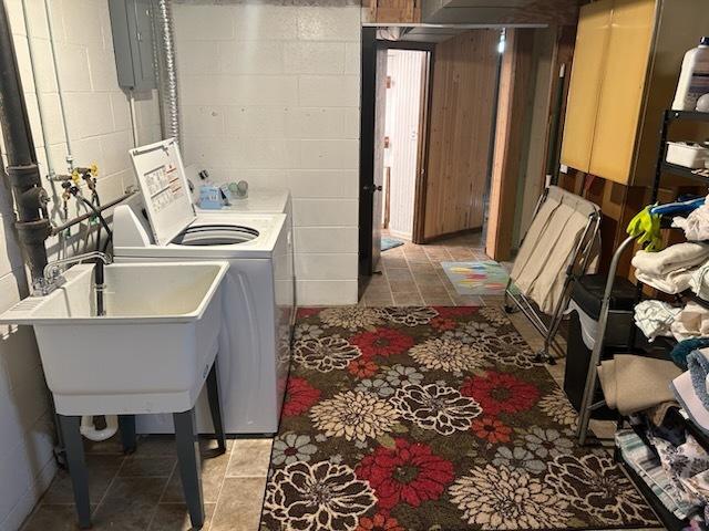 washroom featuring sink, electric panel, and washing machine and clothes dryer