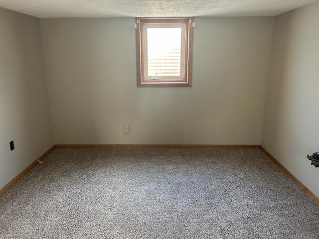 carpeted spare room with a textured ceiling