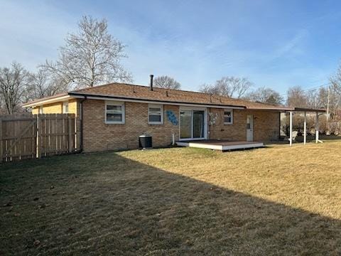 back of property with a wooden deck, a yard, and central air condition unit