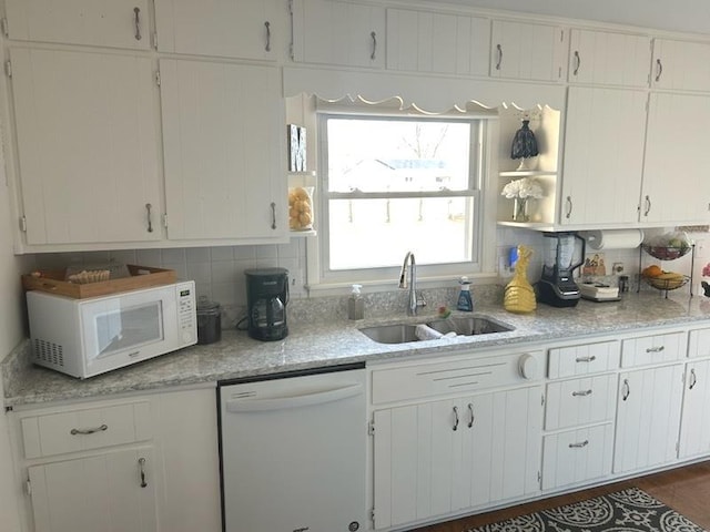 kitchen with white cabinetry, sink, backsplash, and white appliances