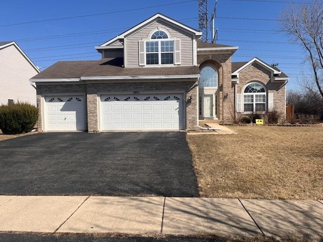 view of front facade featuring aphalt driveway, a garage, and brick siding