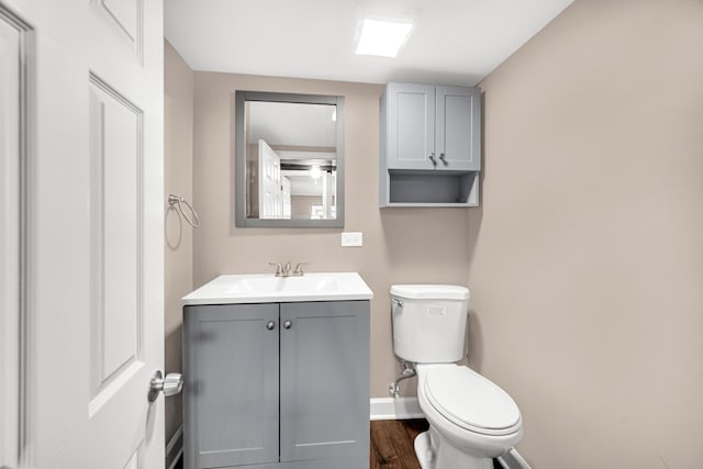 bathroom with hardwood / wood-style flooring, vanity, and toilet