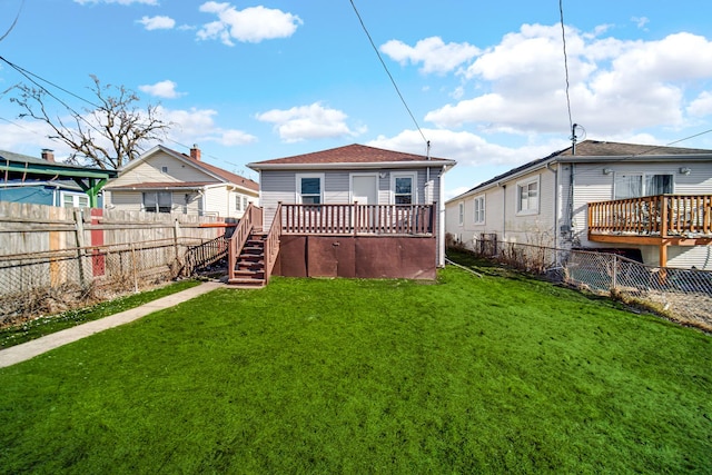 rear view of property with a wooden deck and a lawn