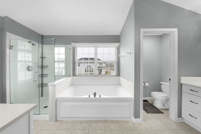 full bathroom with vaulted ceiling, tile patterned flooring, vanity, separate shower and tub, and toilet