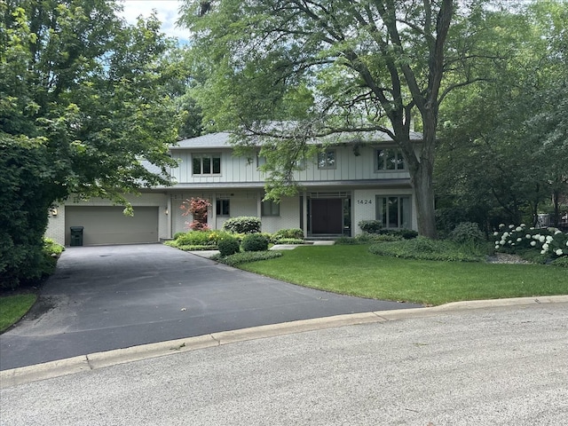 view of front of home with a garage and a front lawn