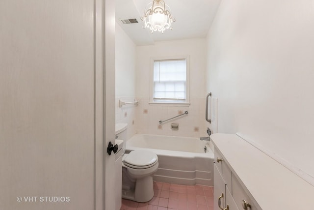 bathroom with tile patterned flooring, vanity, a washtub, toilet, and an inviting chandelier