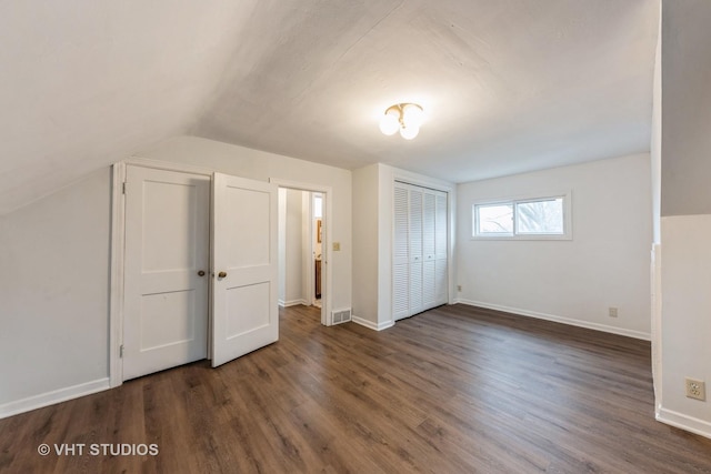 additional living space with dark hardwood / wood-style flooring and vaulted ceiling