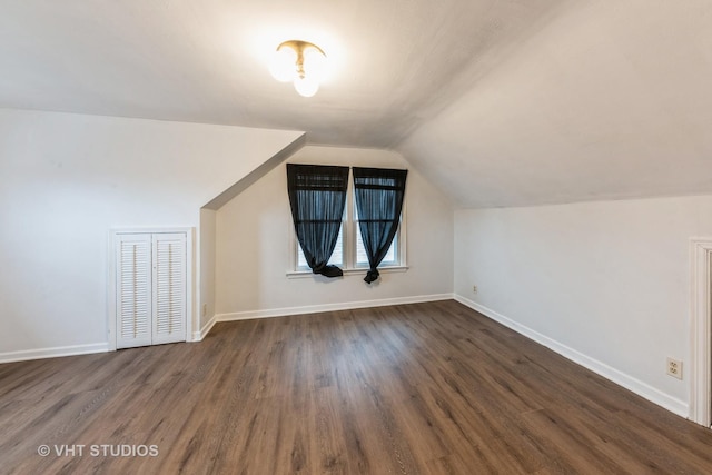 additional living space featuring lofted ceiling and dark hardwood / wood-style flooring