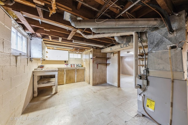 basement with a healthy amount of sunlight and heating unit