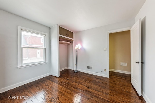 unfurnished bedroom featuring dark hardwood / wood-style flooring and a closet