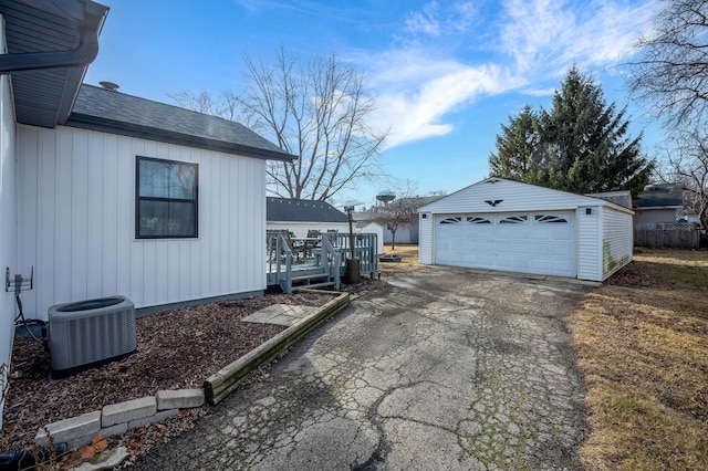 view of home's exterior with cooling unit, a garage, a deck, and an outbuilding