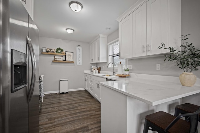 kitchen with a breakfast bar, white cabinets, and stainless steel fridge with ice dispenser