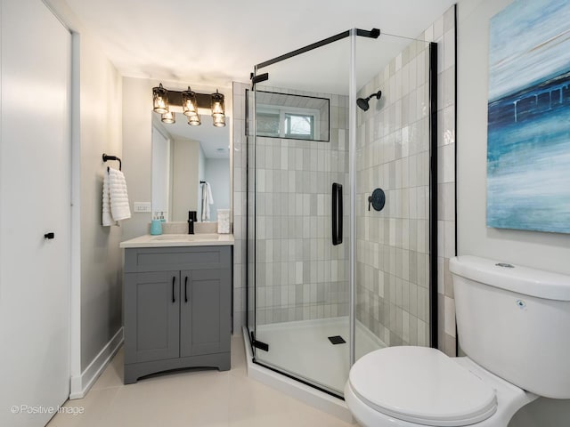 bathroom featuring tile patterned floors, vanity, toilet, and a shower with door