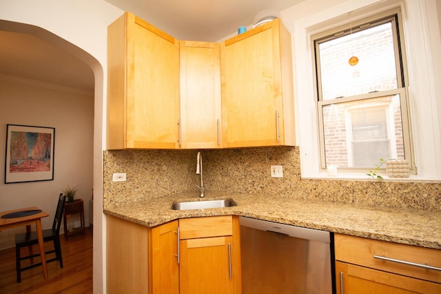 kitchen featuring dishwasher, sink, light stone counters, and decorative backsplash