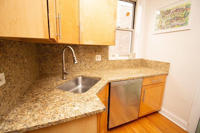 kitchen featuring dishwasher, light stone countertops, sink, and light wood-type flooring