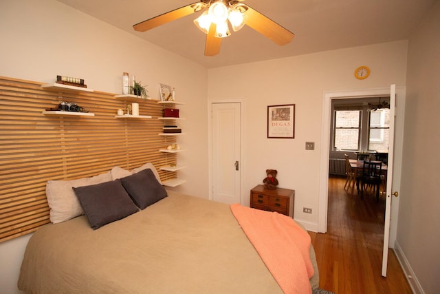 bedroom featuring dark hardwood / wood-style flooring, radiator, and ceiling fan