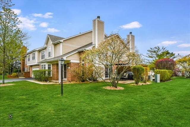 rear view of house featuring a garage and a lawn