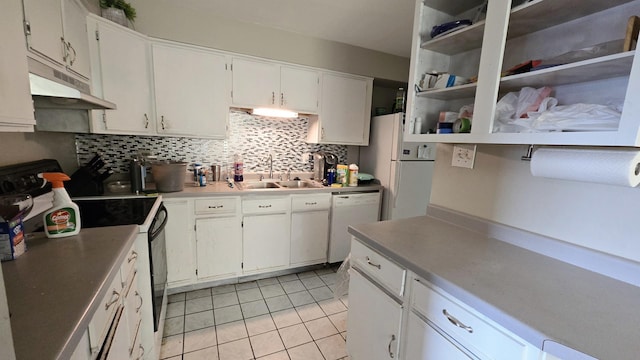 kitchen featuring sink, white appliances, light tile patterned floors, backsplash, and white cabinets