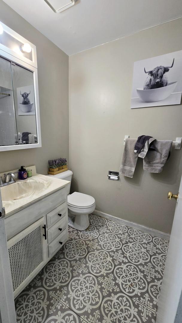 bathroom with tile patterned flooring, vanity, and toilet