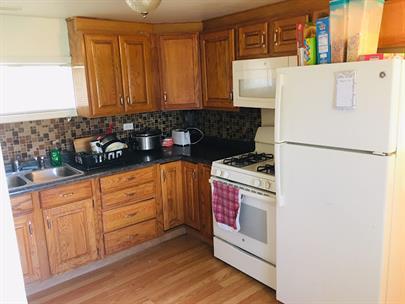 kitchen with sink, backsplash, white appliances, and light hardwood / wood-style floors