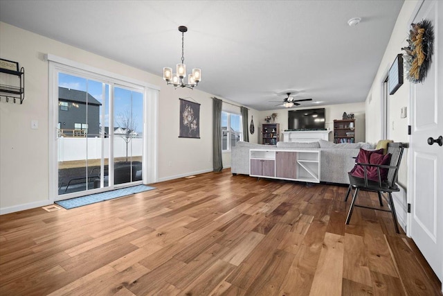 interior space featuring ceiling fan with notable chandelier and hardwood / wood-style floors