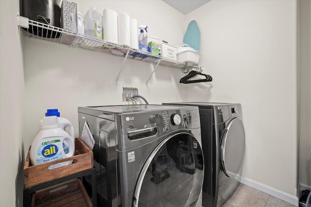 clothes washing area featuring light tile patterned flooring and independent washer and dryer