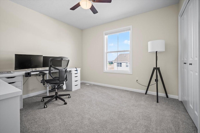 carpeted office space with ceiling fan