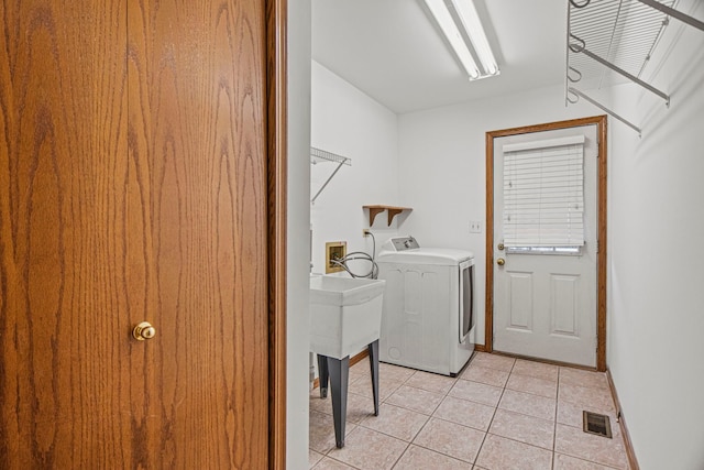 laundry room with light tile patterned floors, visible vents, washer / dryer, laundry area, and baseboards