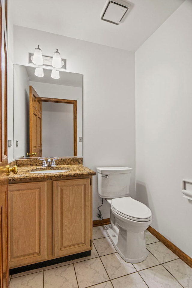 bathroom featuring toilet, visible vents, vanity, baseboards, and tile patterned floors