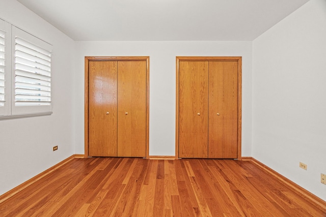 unfurnished bedroom featuring light wood-style floors and baseboards