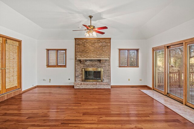 unfurnished living room with a brick fireplace, hardwood / wood-style floors, and ceiling fan