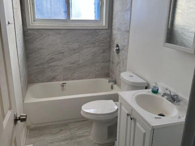 full bathroom with vanity, tiled shower / bath, and toilet