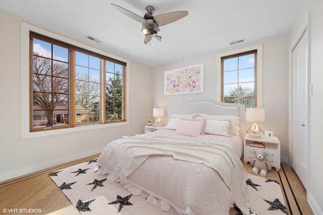 bedroom with ceiling fan, wood-type flooring, and a closet