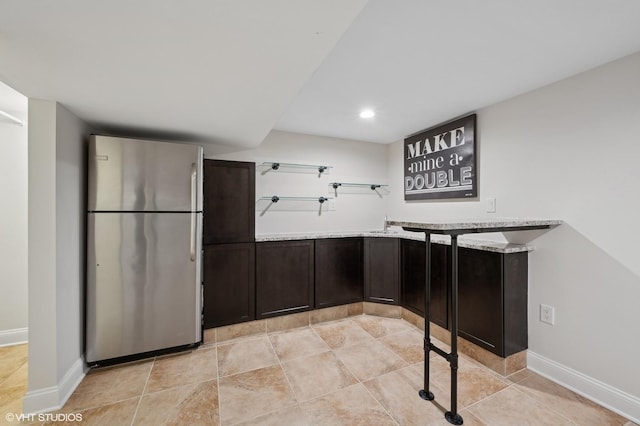 kitchen featuring stainless steel refrigerator and light tile patterned floors