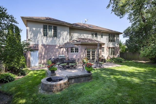 back of property featuring french doors, an outdoor fire pit, a patio area, and a lawn