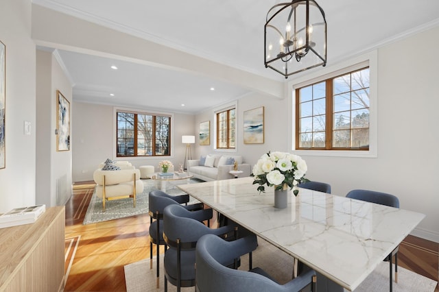 dining room featuring ornamental molding, a chandelier, and light wood-type flooring