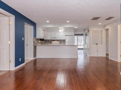 unfurnished living room featuring dark hardwood / wood-style flooring and a textured ceiling