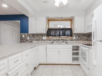 kitchen with white cabinetry, sink, white appliances, and tasteful backsplash