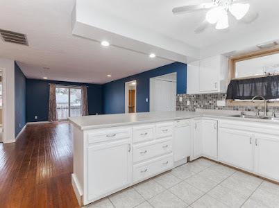 kitchen featuring sink, ceiling fan, white cabinets, decorative backsplash, and kitchen peninsula